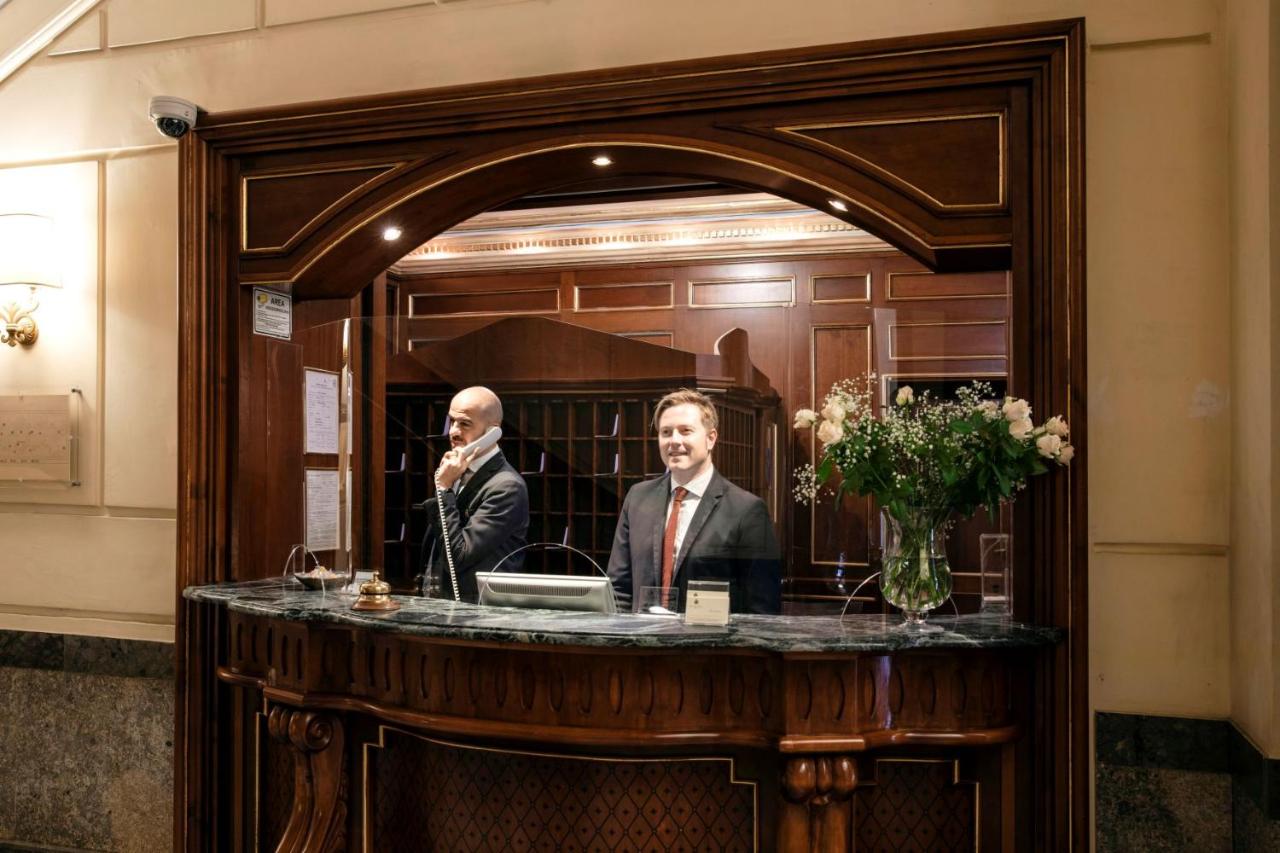 een man die aan een tafel voor een spiegel zit bij Grand Hotel Wagner in Palermo