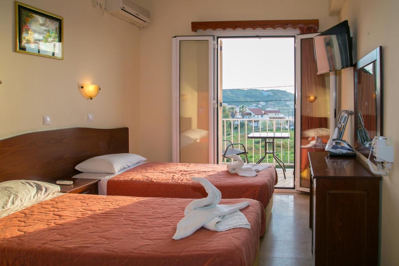 een hotelkamer met twee bedden en een balkon bij Kouros Apartments & Studios By Hotelius in Agios Stefanos