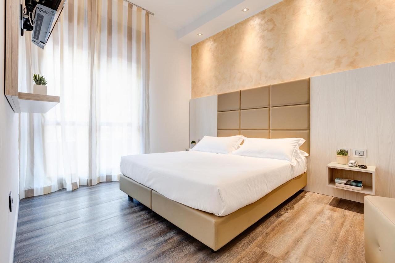 een slaapkamer met een groot bed en een groot raam bij Hotel Piccadilly in Lido di Jesolo