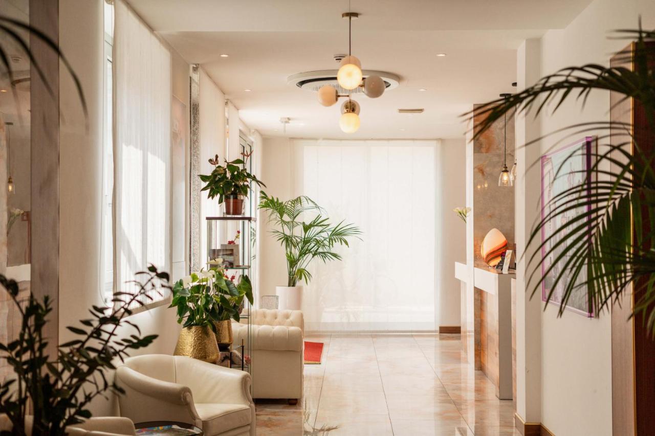 een woonkamer met potplanten en een groot raam bij Hotel Piccadilly in Lido di Jesolo