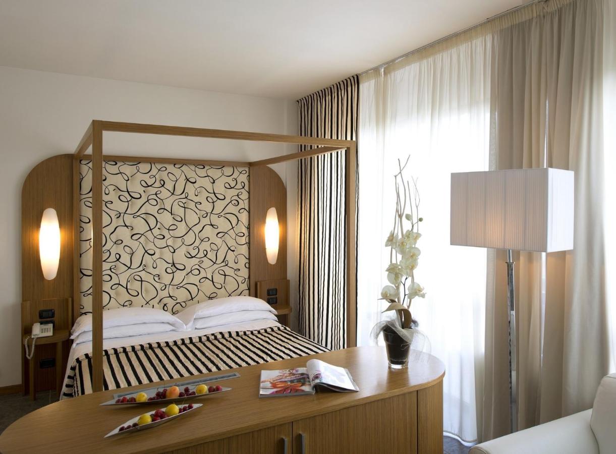 een slaapkamer met een bed en een bureau met een lamp bij Grand Hotel Admiral Palace in Chianciano Terme
