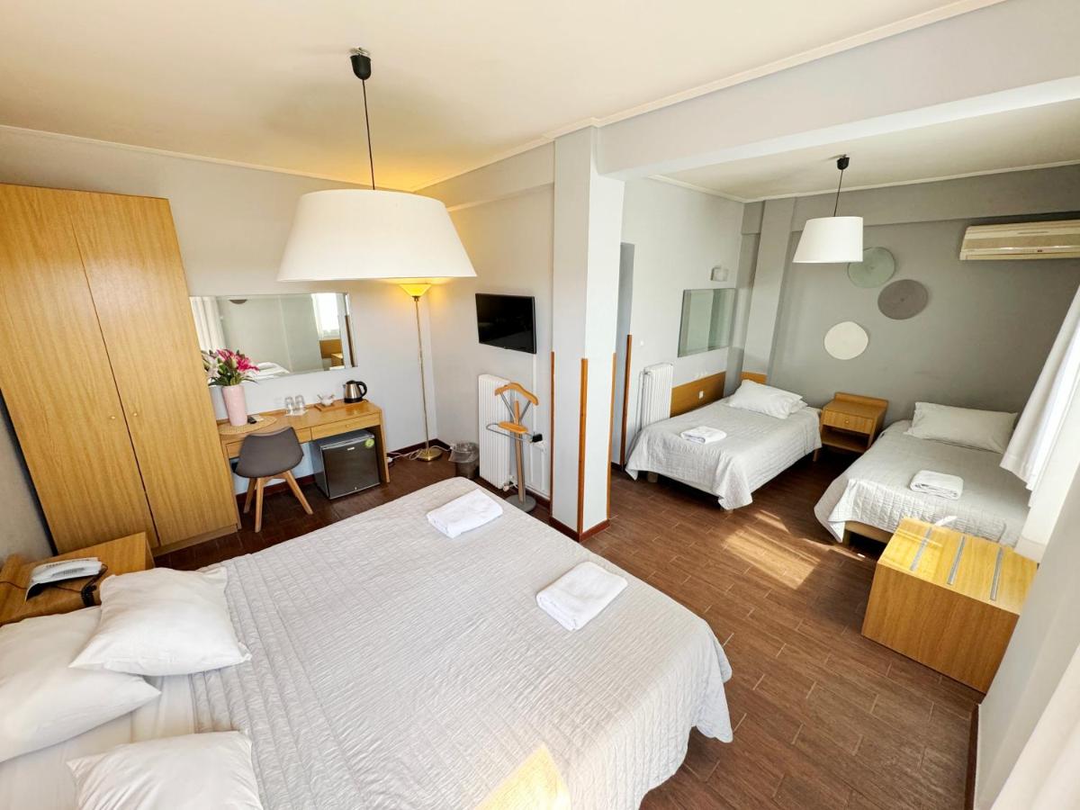 een hotelkamer met twee bedden en een bureau bij Myrto Hotel in Mati