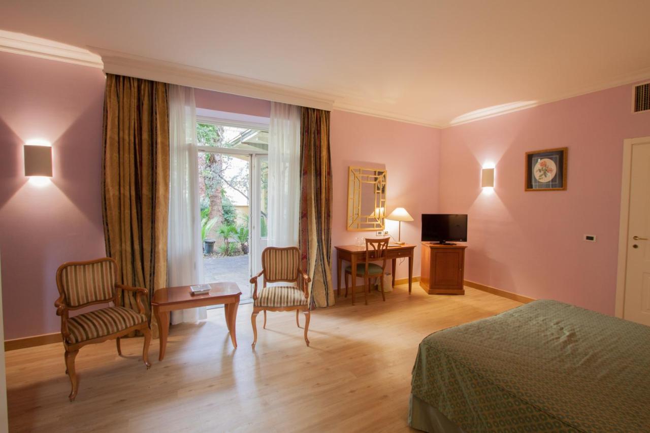 een slaapkamer met een bed, een bureau en een raam bij Ateneo Garden Palace in Rome