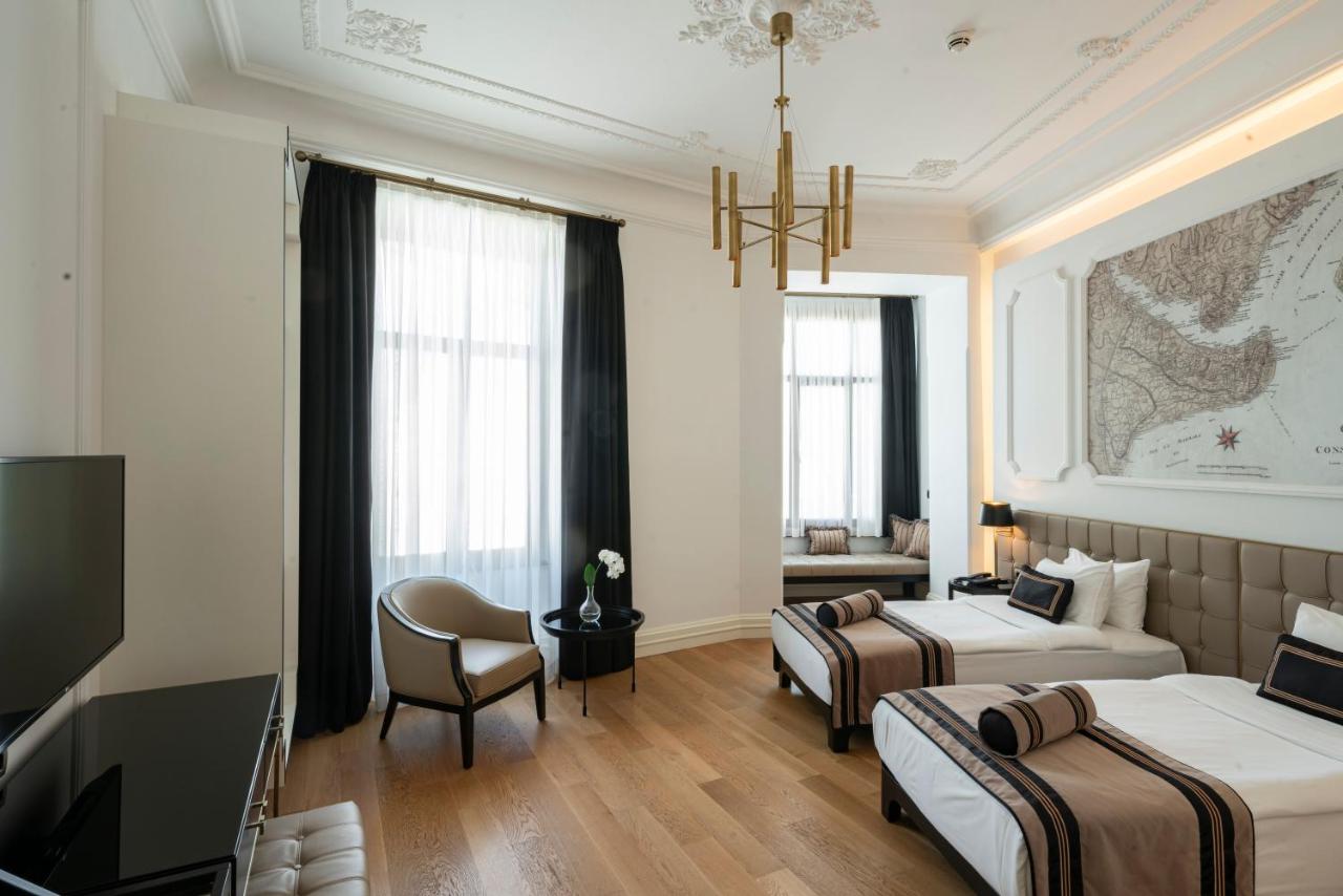een hotelkamer met twee bedden en een televisie bij AKKA Lush Hotel Taksim in Istanbul