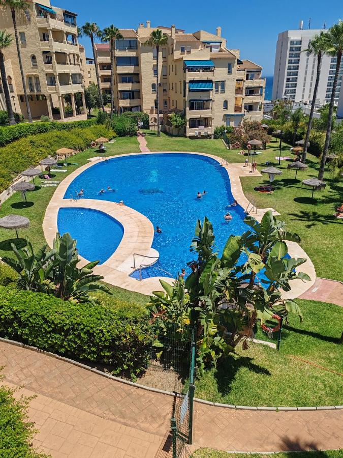 een groot zwembad in een park met gebouwen bij Casinomar in Benalmádena