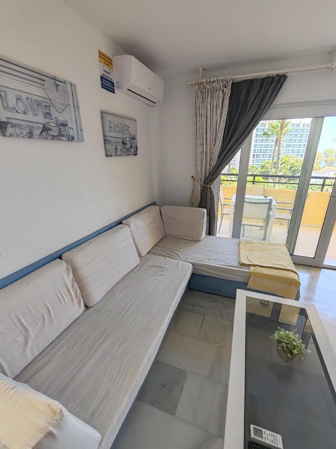 een woonkamer met twee bedden en een raam bij Casinomar in Benalmádena