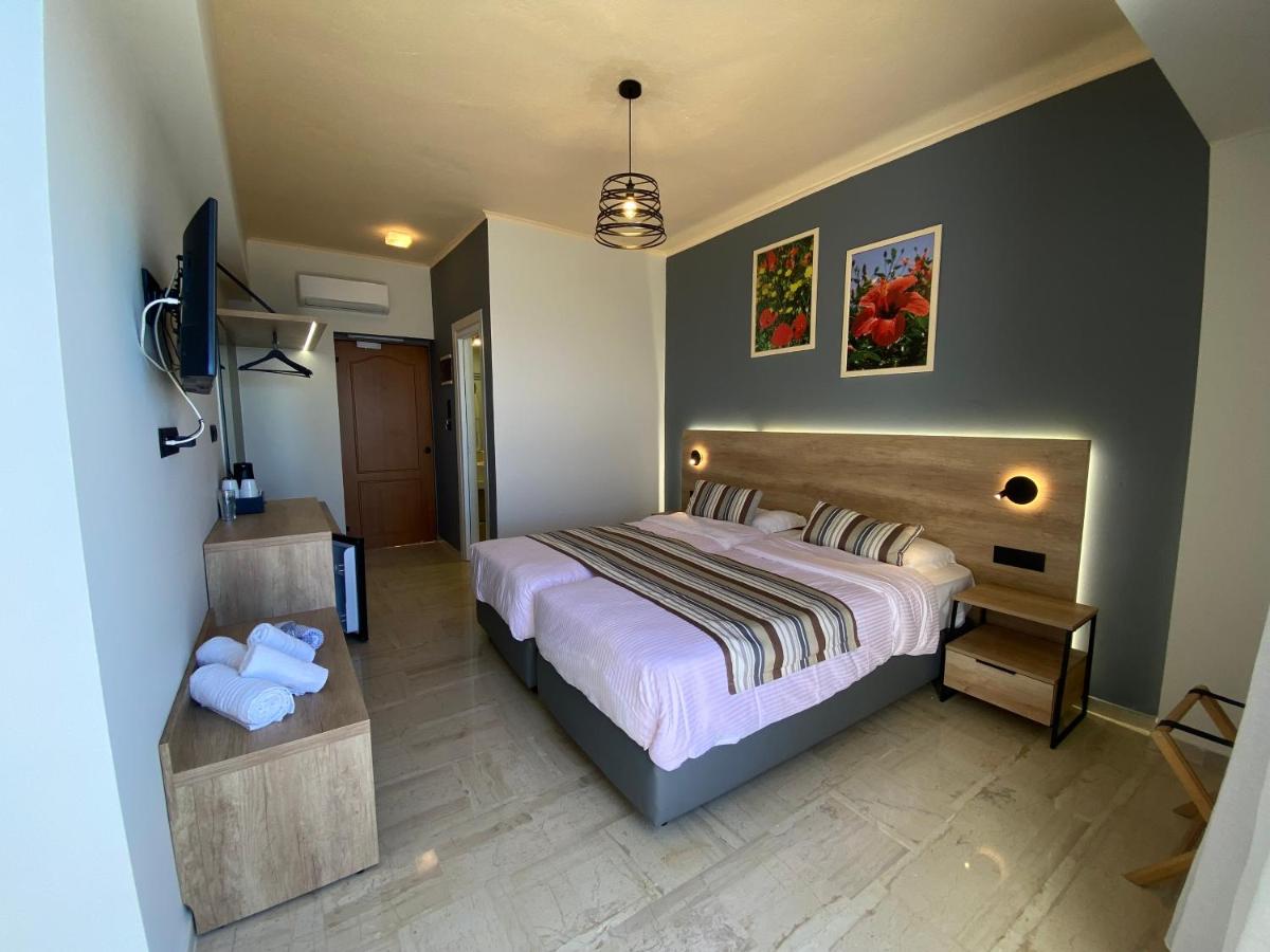 een slaapkamer met een bed en een flatscreen-tv bij Horizon Beach Hotel in Plakias