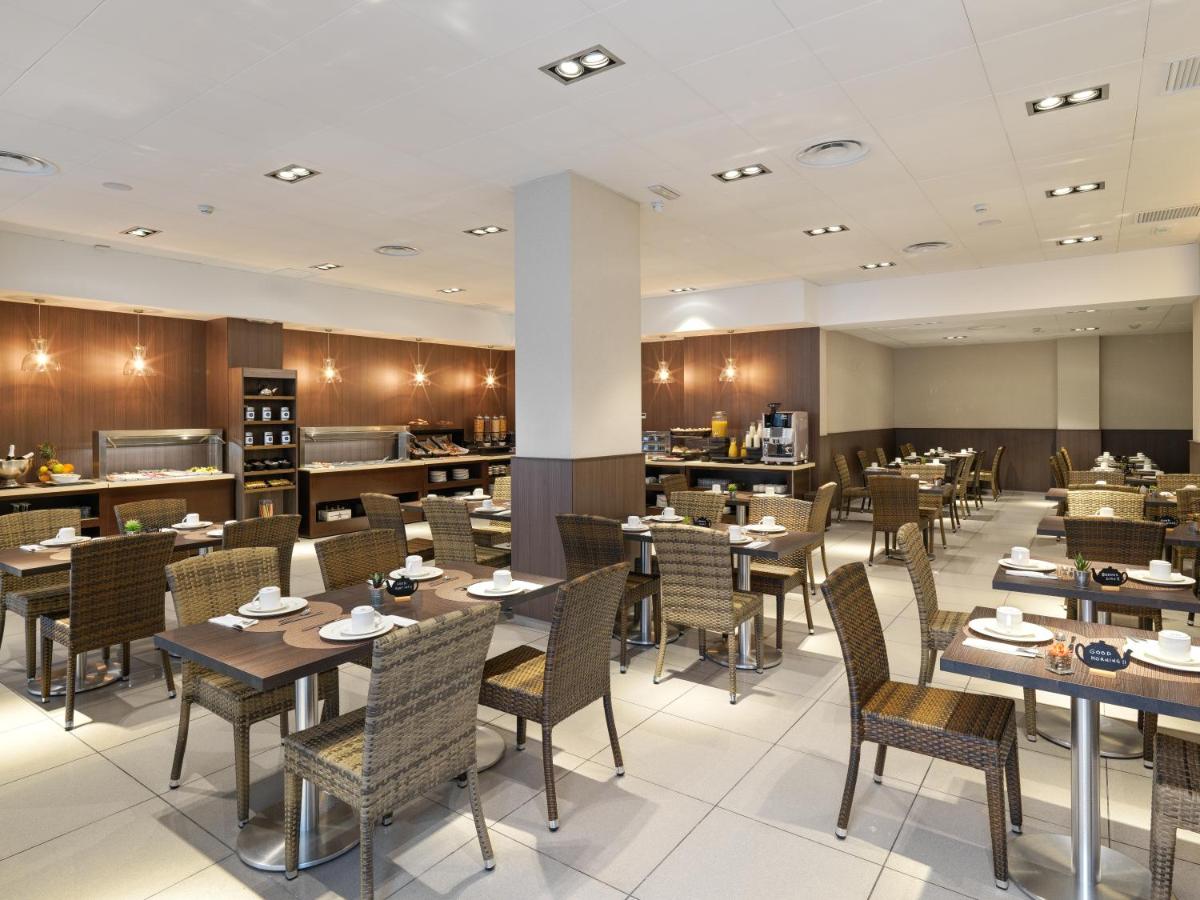een eetzaal met tafels en stoelen en een restaurant bij Hotel Guadalmedina in Málaga