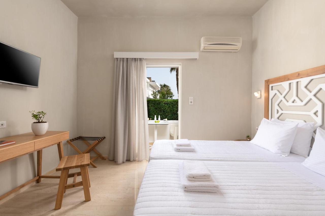 een slaapkamer met twee bedden, een bureau en een televisie bij Apollo Plakias in Plakias