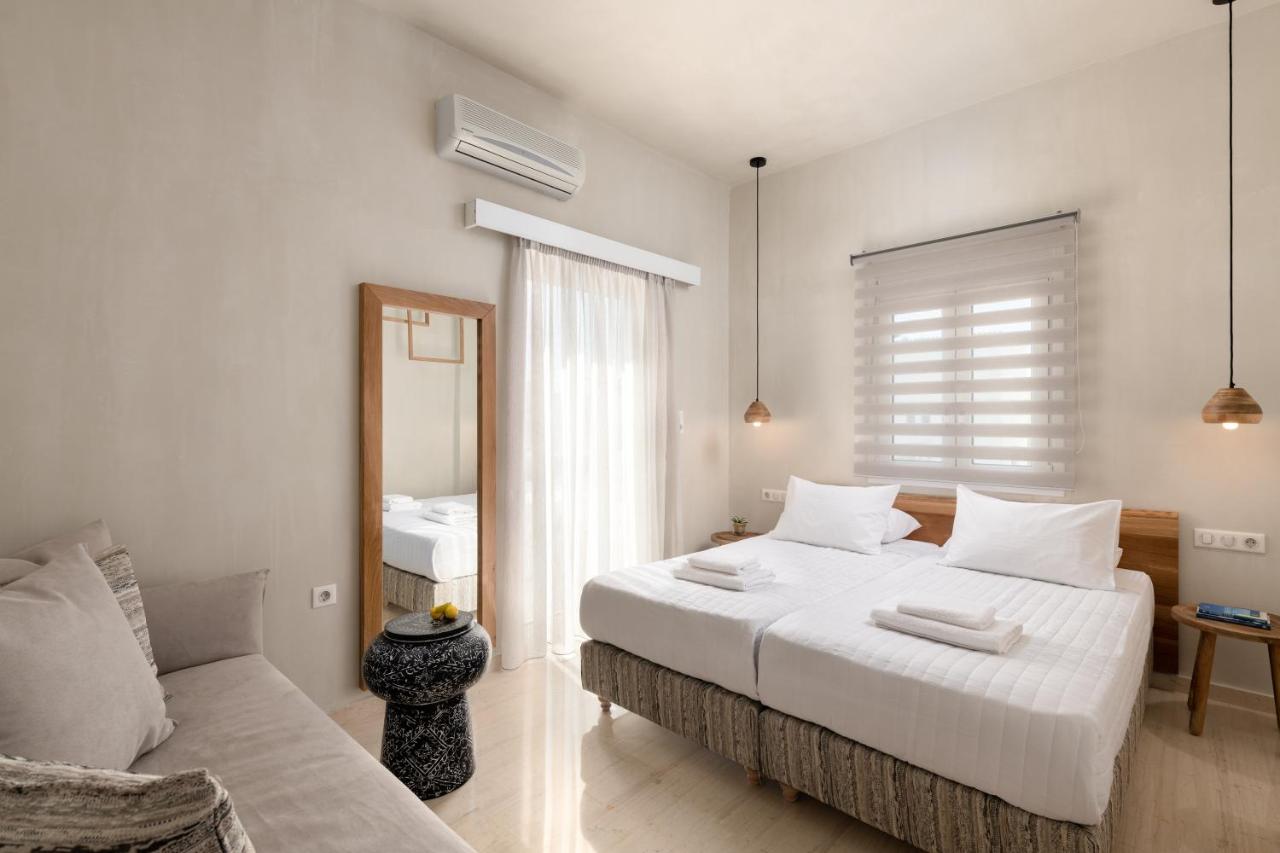 een witte slaapkamer met een bed en een bank bij Apollo Plakias in Plakias +128 foto's