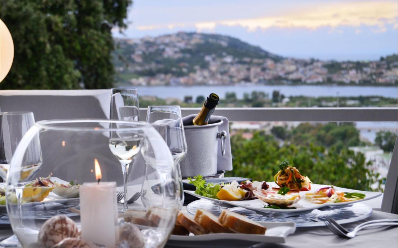 een tafel met een bord eten en wijnglazen bij Hotel Cala Moresca in Bacoli
