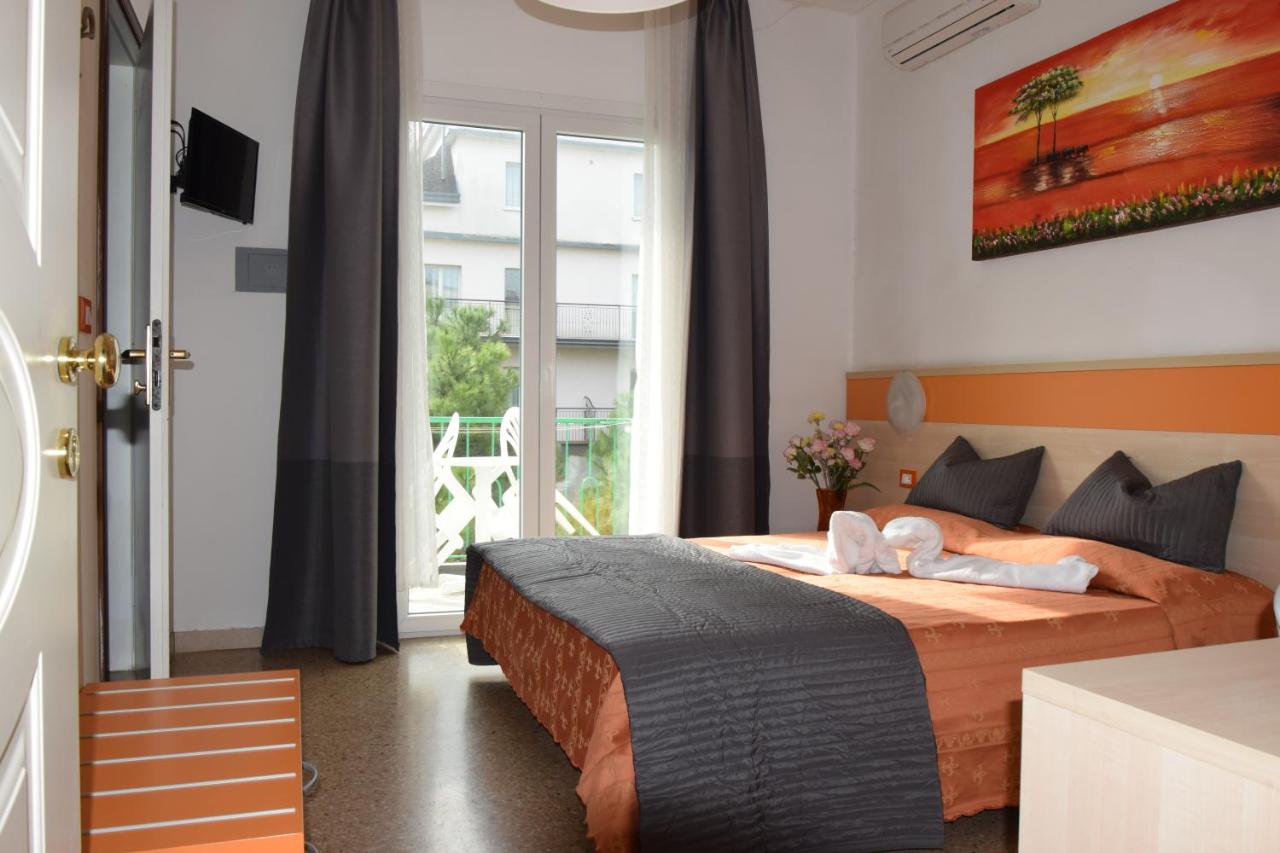 een slaapkamer met een bed en een groot raam bij Hotel Verdi in Lido di Jesolo