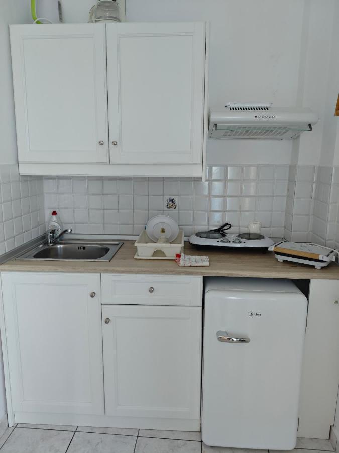 een keuken met witte kasten en een spoelbak bij Nefeli in Lefkos Karpathou