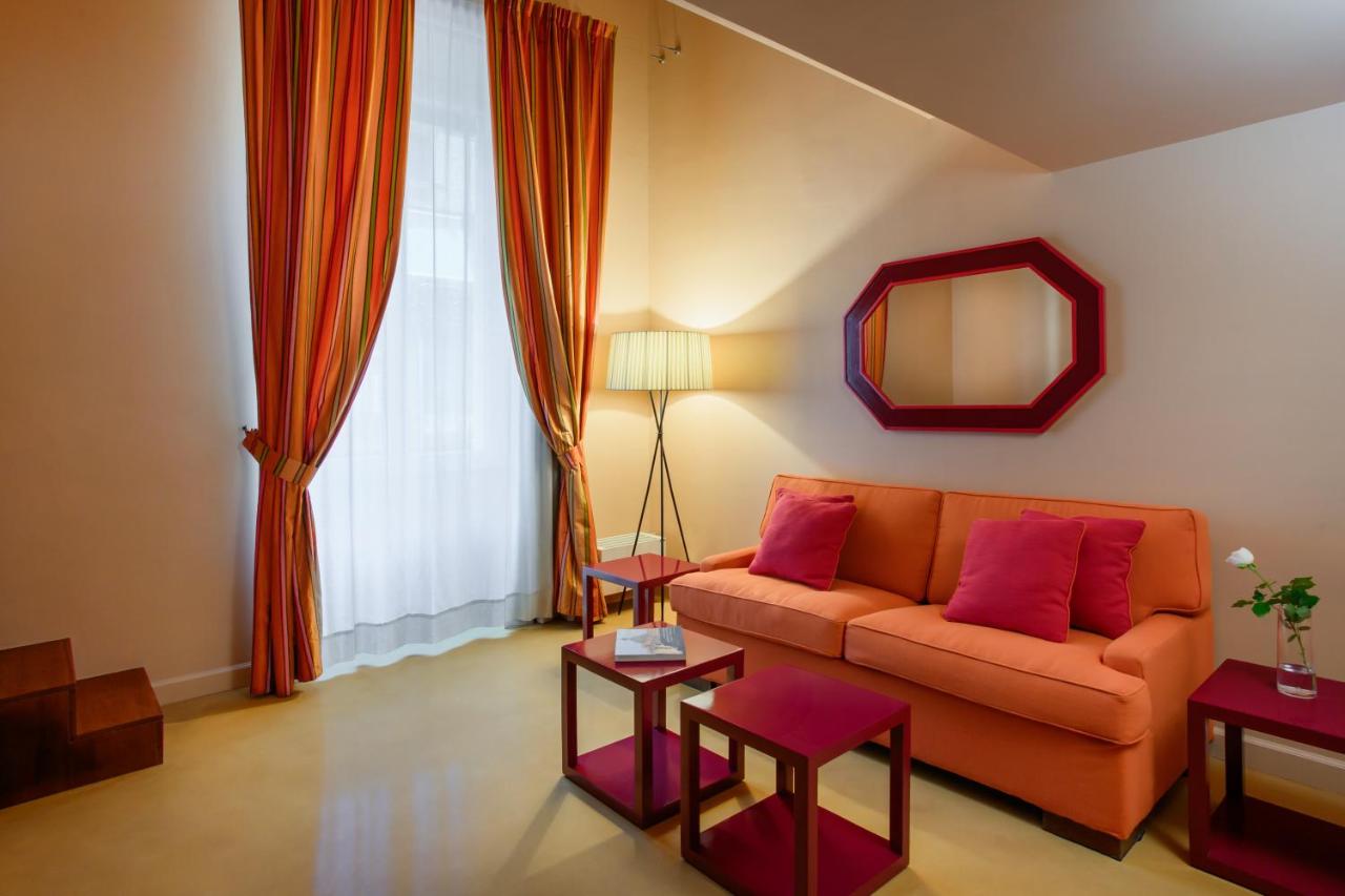 een woonkamer met een oranje bank en een spiegel bij Prêtáloger Verdi 18 in Napels
