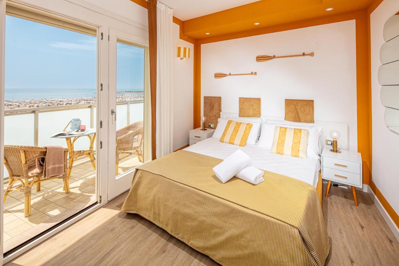 een slaapkamer met een bed en een balkon bij Hotel Karinzia in Caorle