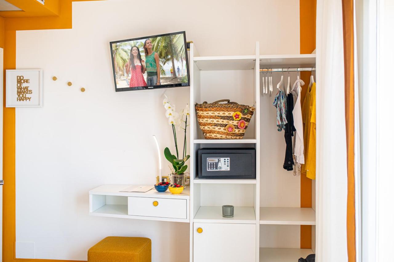 een kast met witte planken en een tv aan de muur bij Hotel Karinzia in Caorle