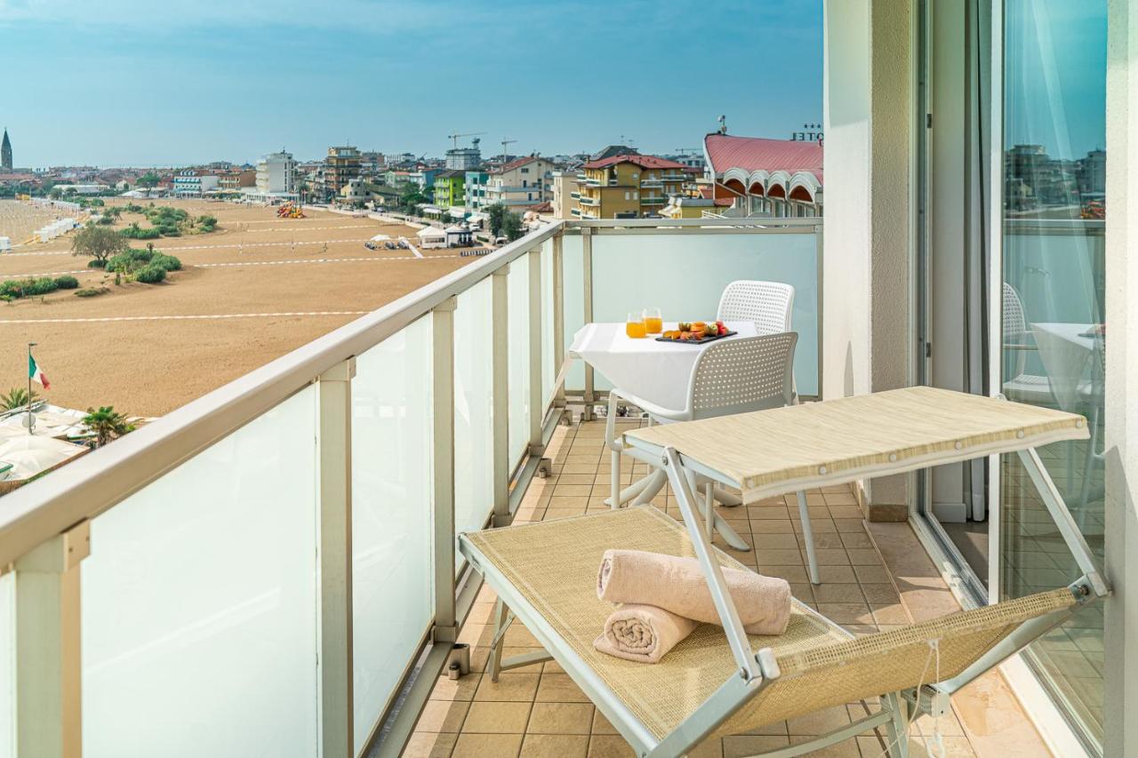 een balkon met een tafel en uitzicht op de stad bij Hotel Karinzia in Caorle