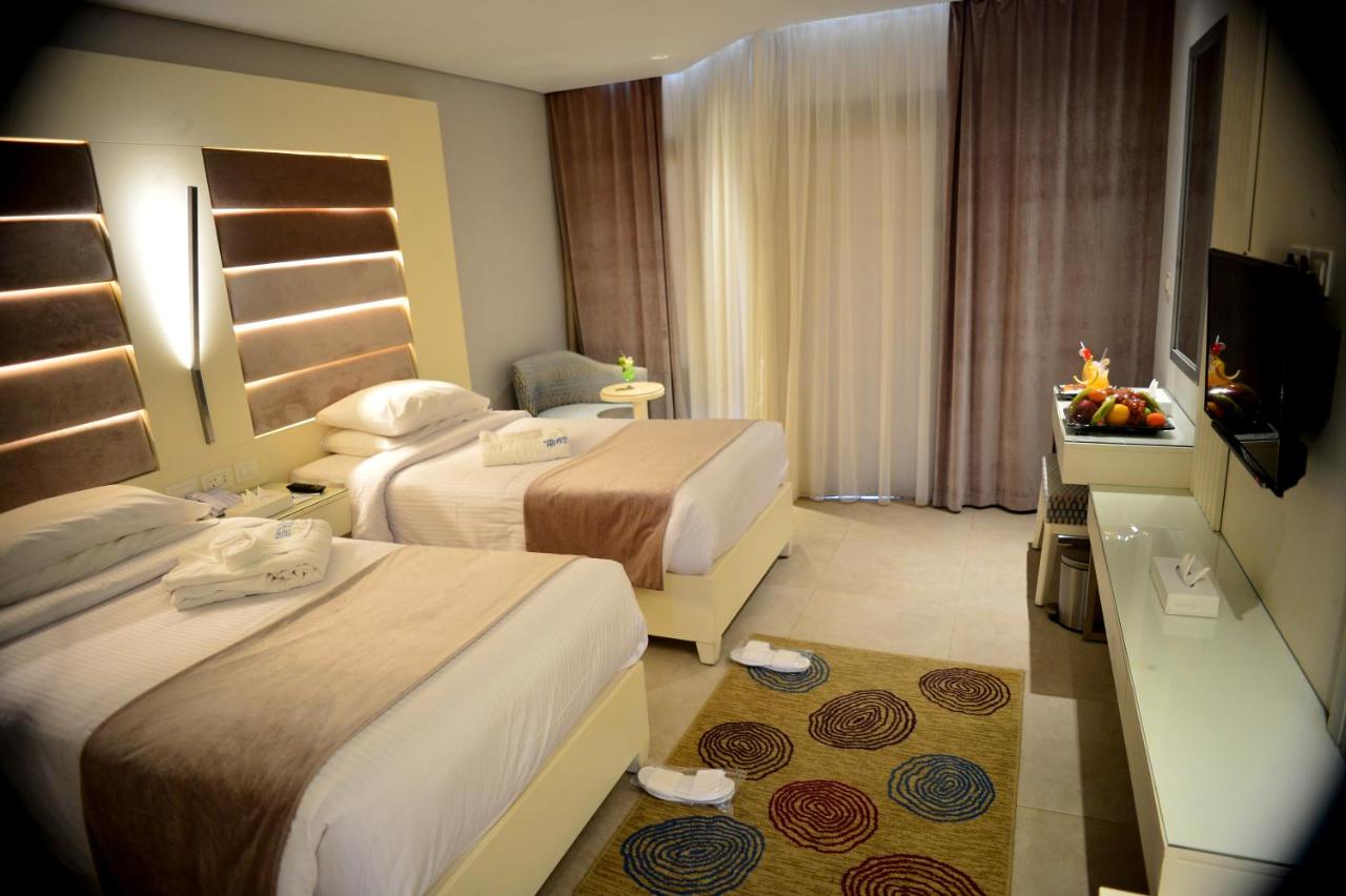 een hotelkamer met twee bedden en een televisie bij Marina Sharm Hotel in Sharm El Sheikh