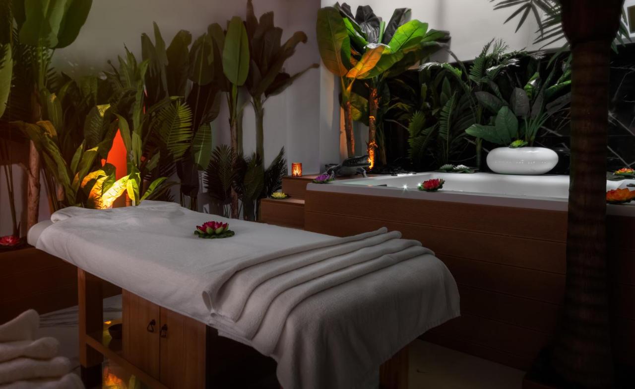 een badkamer met planten en een badkuip met een tafel bij Elia Ermou Athens Hotel in Athene