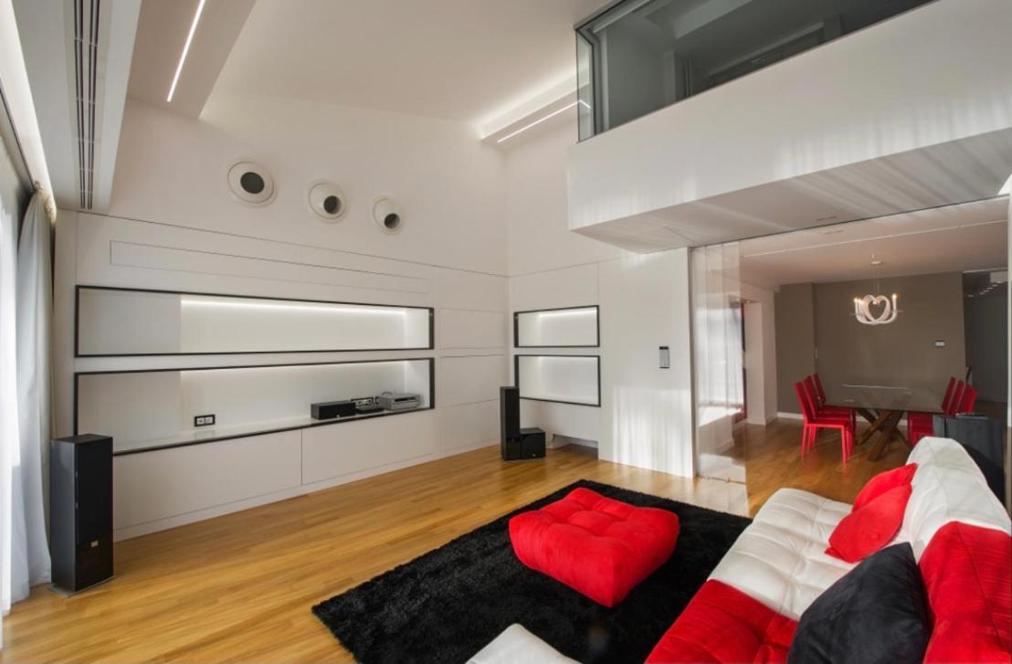 een woonkamer met een bank en een rode stoel bij Suite Testani in Frosinone