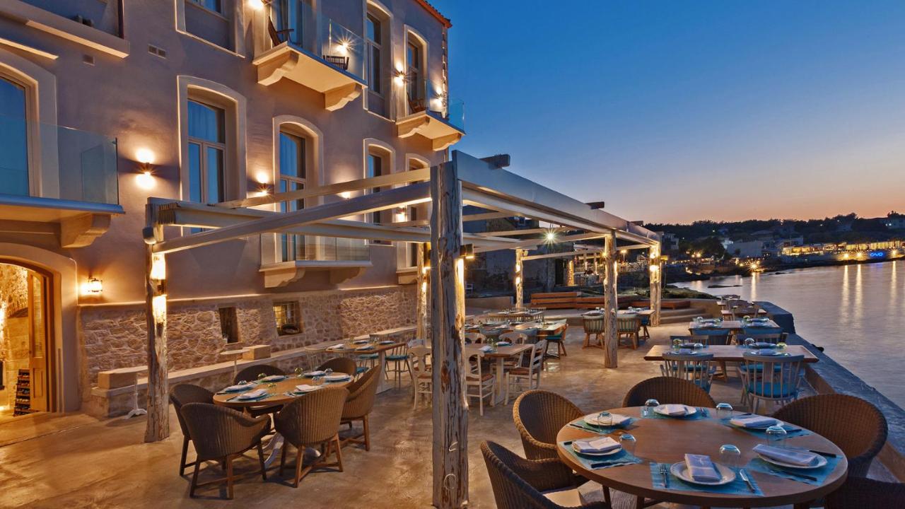een restaurant met tafels en stoelen aan het water bij Thalassa Boutique Hotel in Rethimnon