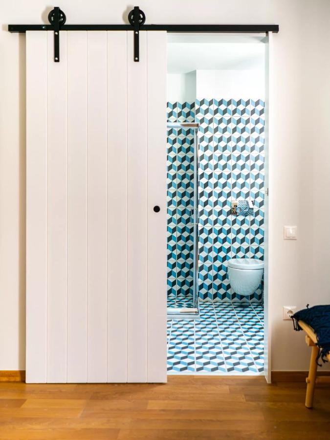 een badkamer met een schuifdeur die toegang geeft tot een badkuip bij Iasonos Suites Athens in Athene