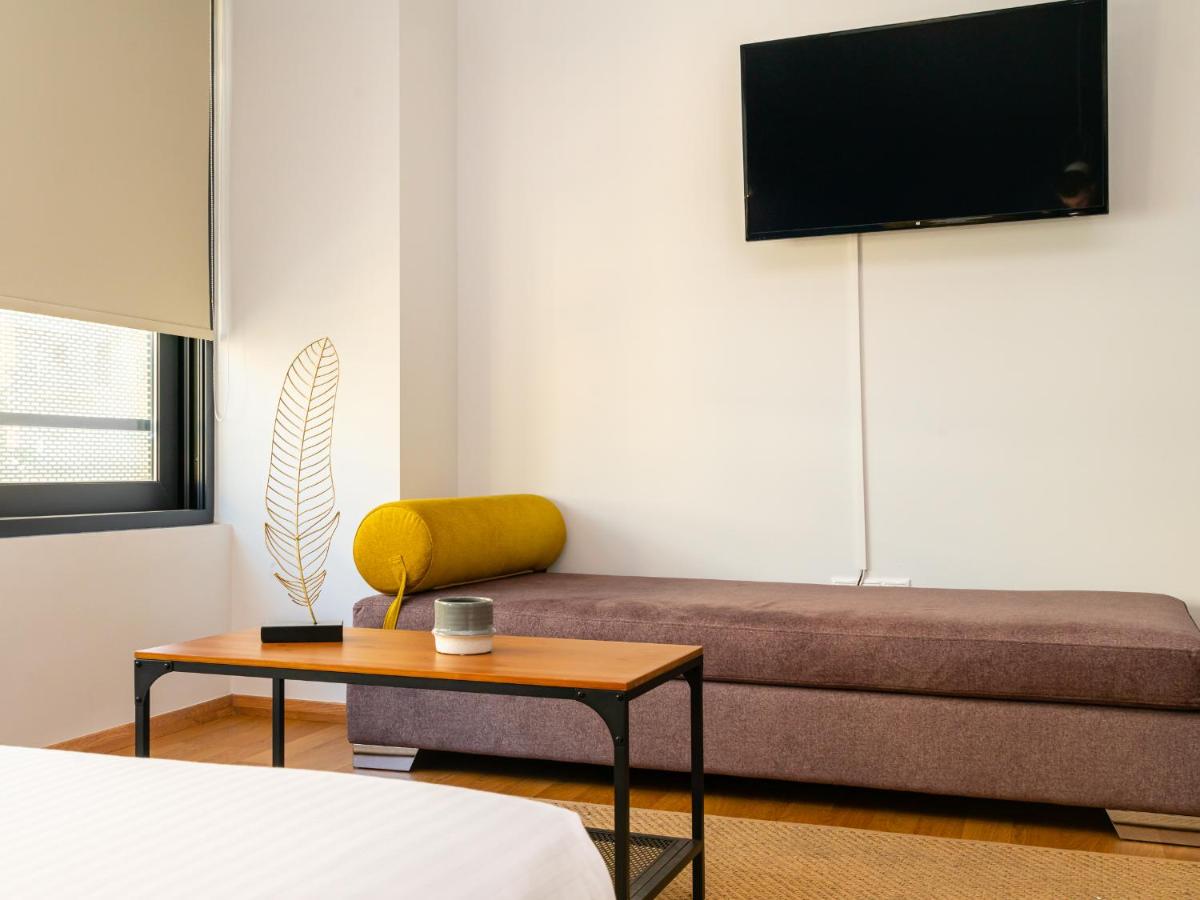 een woonkamer met een bank en een salontafel bij Iasonos Suites Athens in Athene