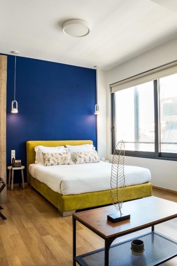 een slaapkamer met een bed en een blauwe muur bij Iasonos Suites Athens in Athene