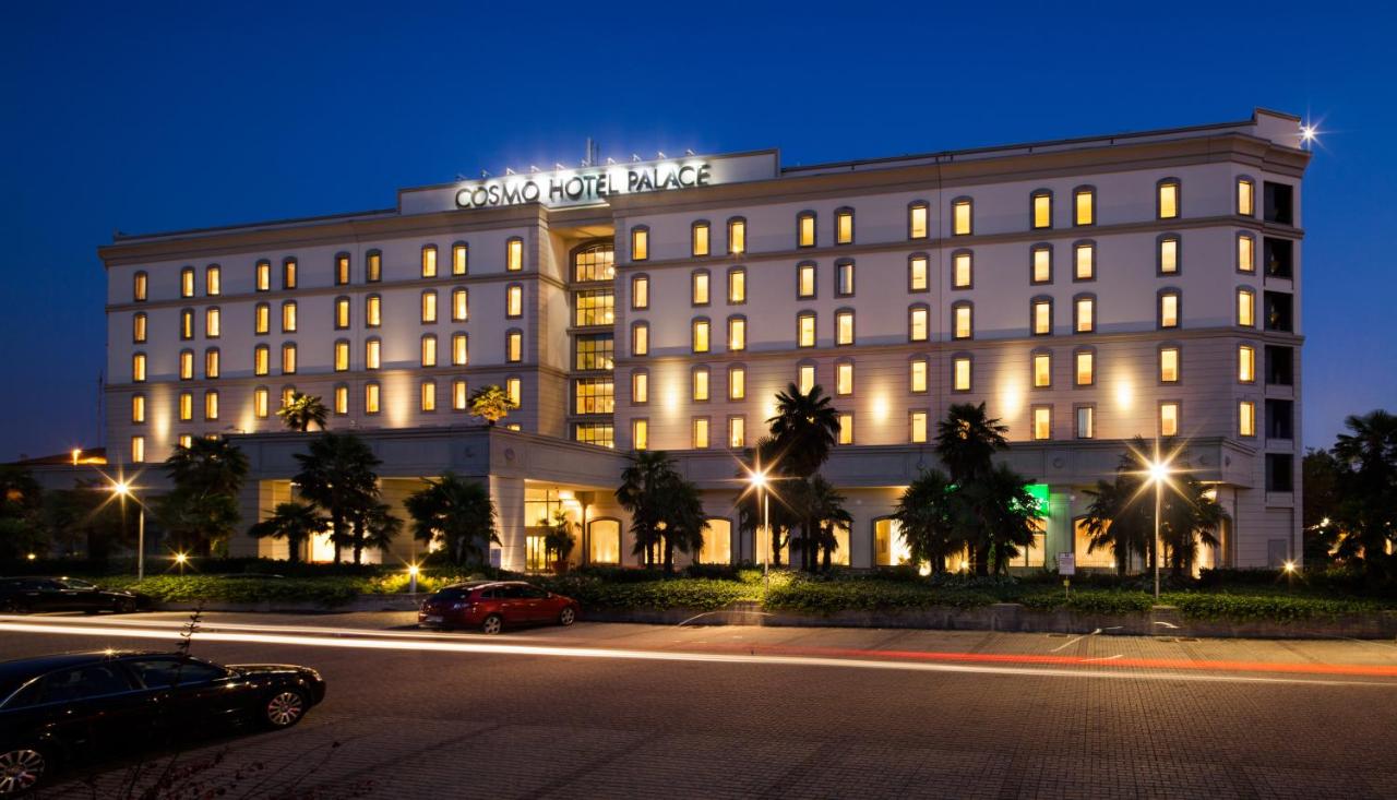 een gebouw met een uithangbord erop 's nachts bij Cosmo Hotel Palace in Cinisello Balsamo