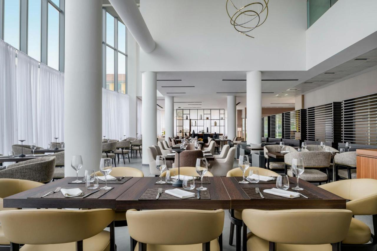 een eetkamer met een grote tafel en stoelen bij AC Hotel by Marriott Milan Sesto in Sesto San Giovanni