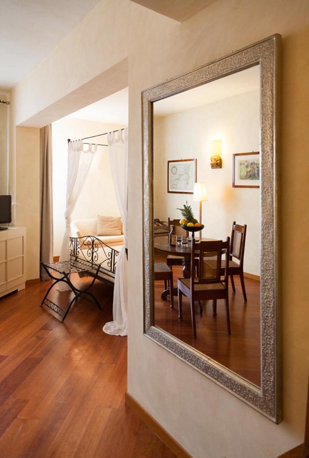 een spiegel die aan de muur in een woonkamer hangt bij Cosmo Hotel Torri in Vimercate