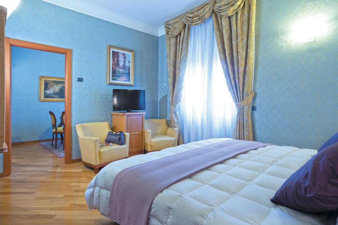 een slaapkamer met een bed en een kamer met een televisie bij Ele Green Park Hotel Pamphili in Rome
