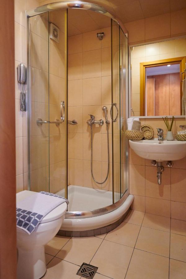 een badkamer met een douche, een toilet en een wastafel bij Crystal City Hotel in Athene