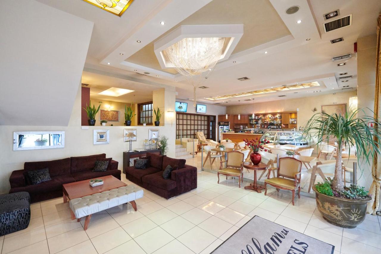 een grote woonkamer met een bank en een tafel bij Crystal City Hotel in Athene