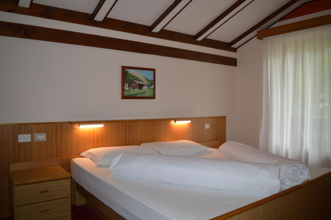een groot wit bed in een slaapkamer met een raam bij Hotel Stella Alpina in Bellamonte