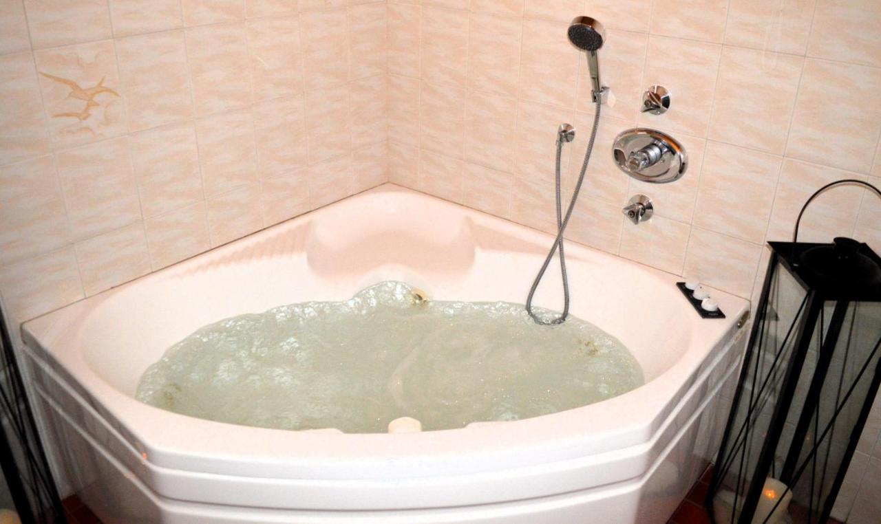 een badkuip gevuld met water in een badkamer bij Hotel Stella Alpina in Bellamonte
