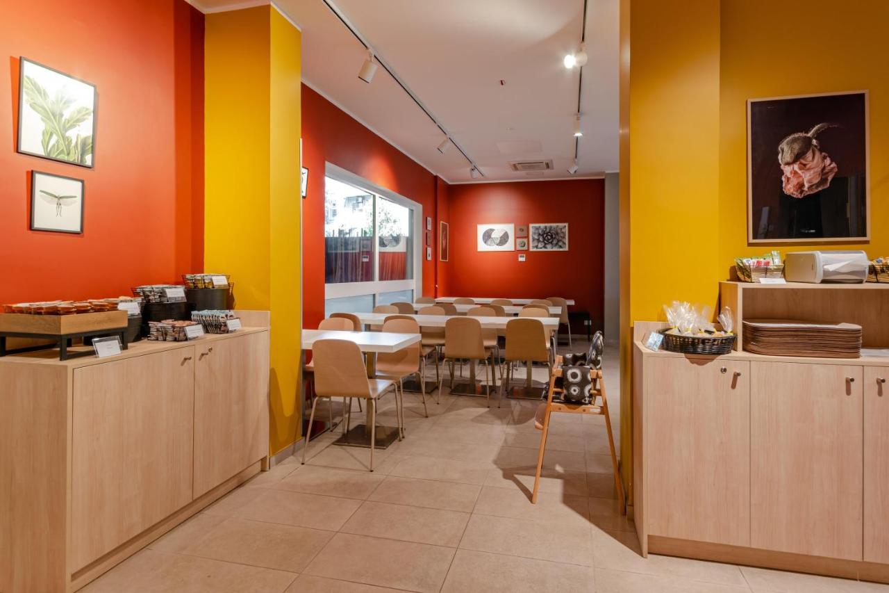 een eetkamer met een tafel en gele en oranje muren bij B&B Hotel Roma Pietralata Tiburtina in Rome