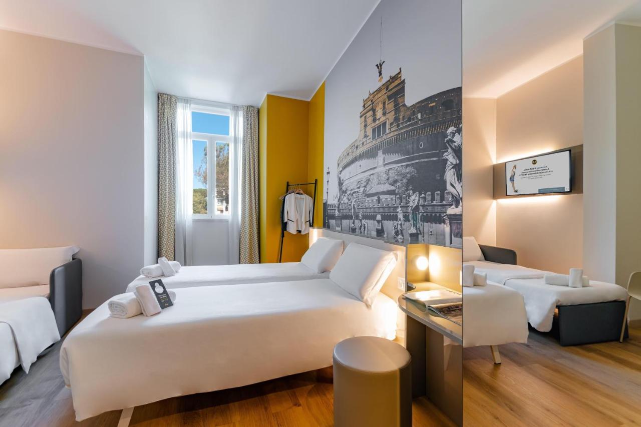 een hotelkamer met een wit bed en een bank bij B&B Hotel Roma Pietralata Tiburtina in Rome